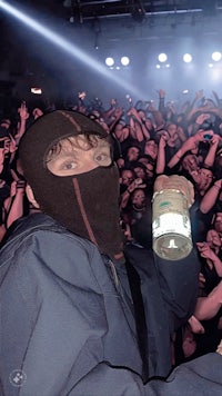 a man holding a bottle in front of a crowd