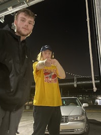 two men standing in front of a car at night